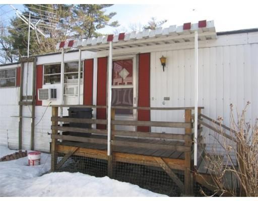 A white house with red shutters and a wooden deck