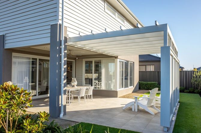 Patio with white outdoor chairs and covered veranda beside a modern house