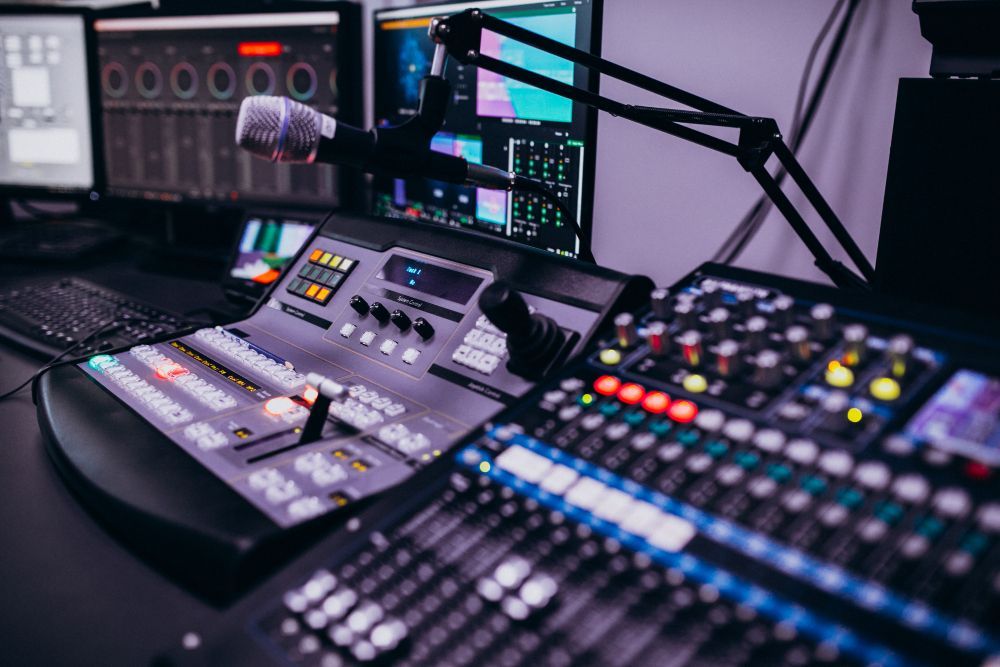Audio mixing console and microphones in a dimly lit recording studio