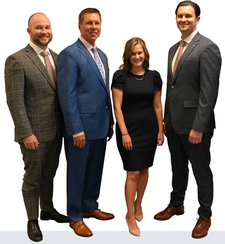 Group of four professionals posing for a photo: three men and one woman in suits and a dress.