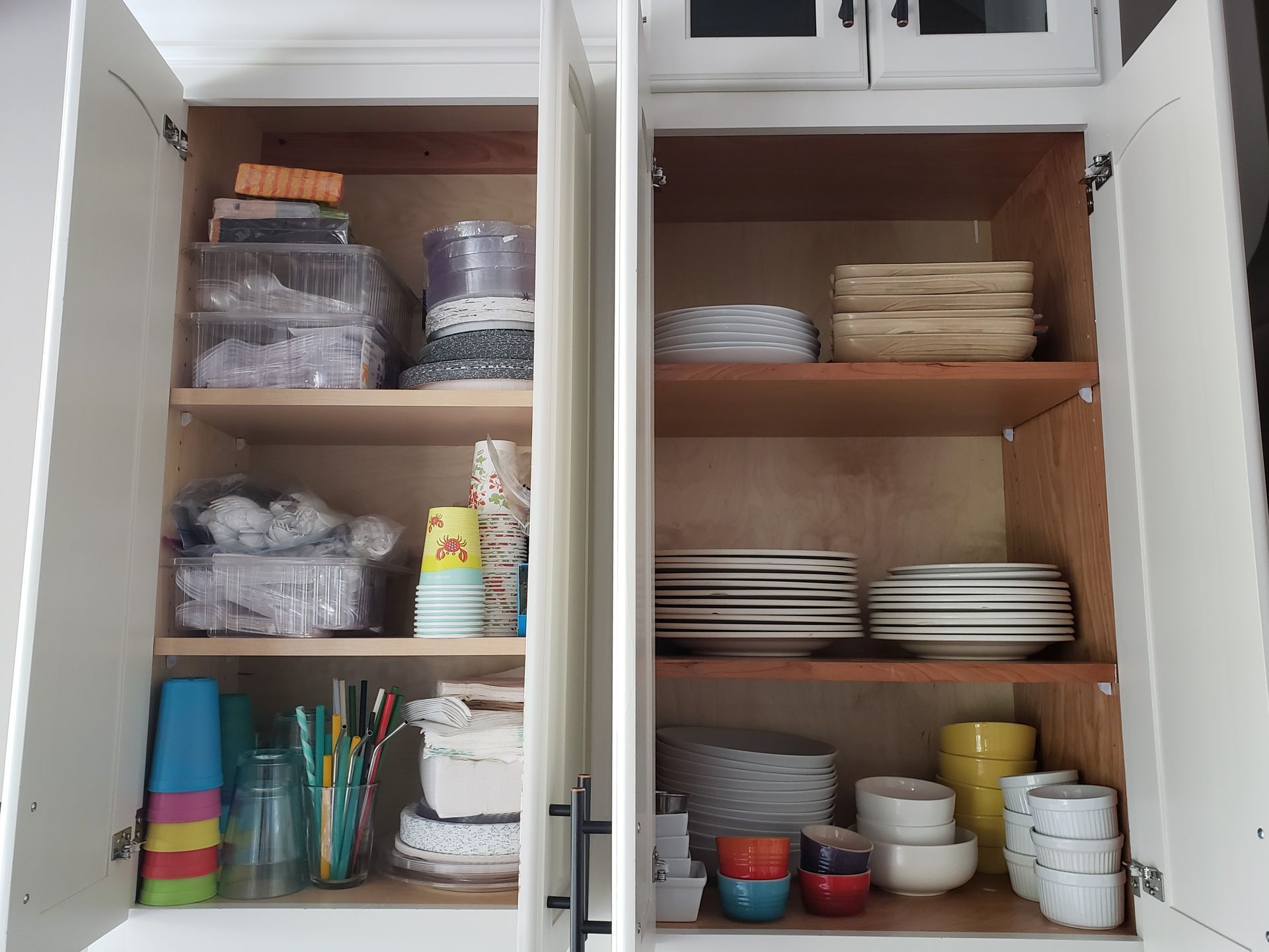 The inside of a kitchen cabinet filled with plates and bowls