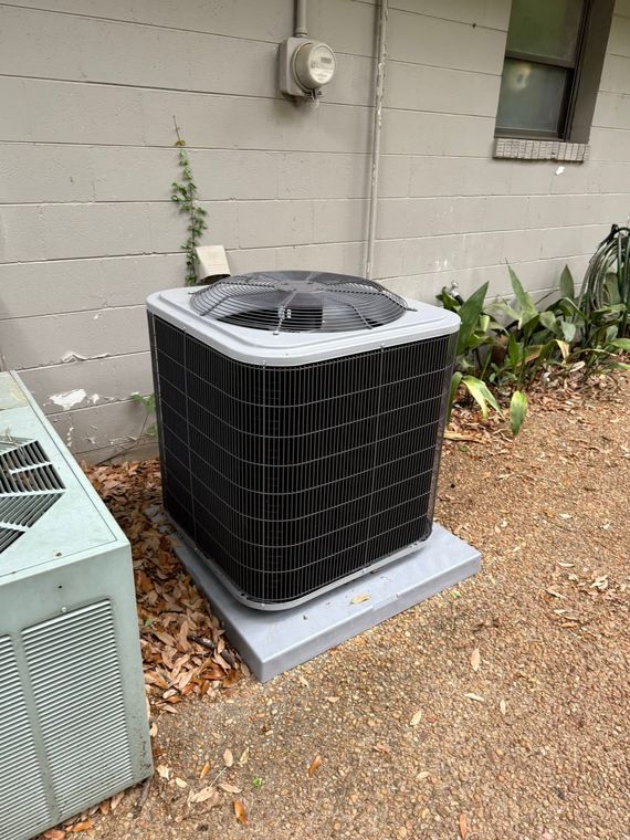 Technician using gauges to service outdoor HVAC unit with exposed panel