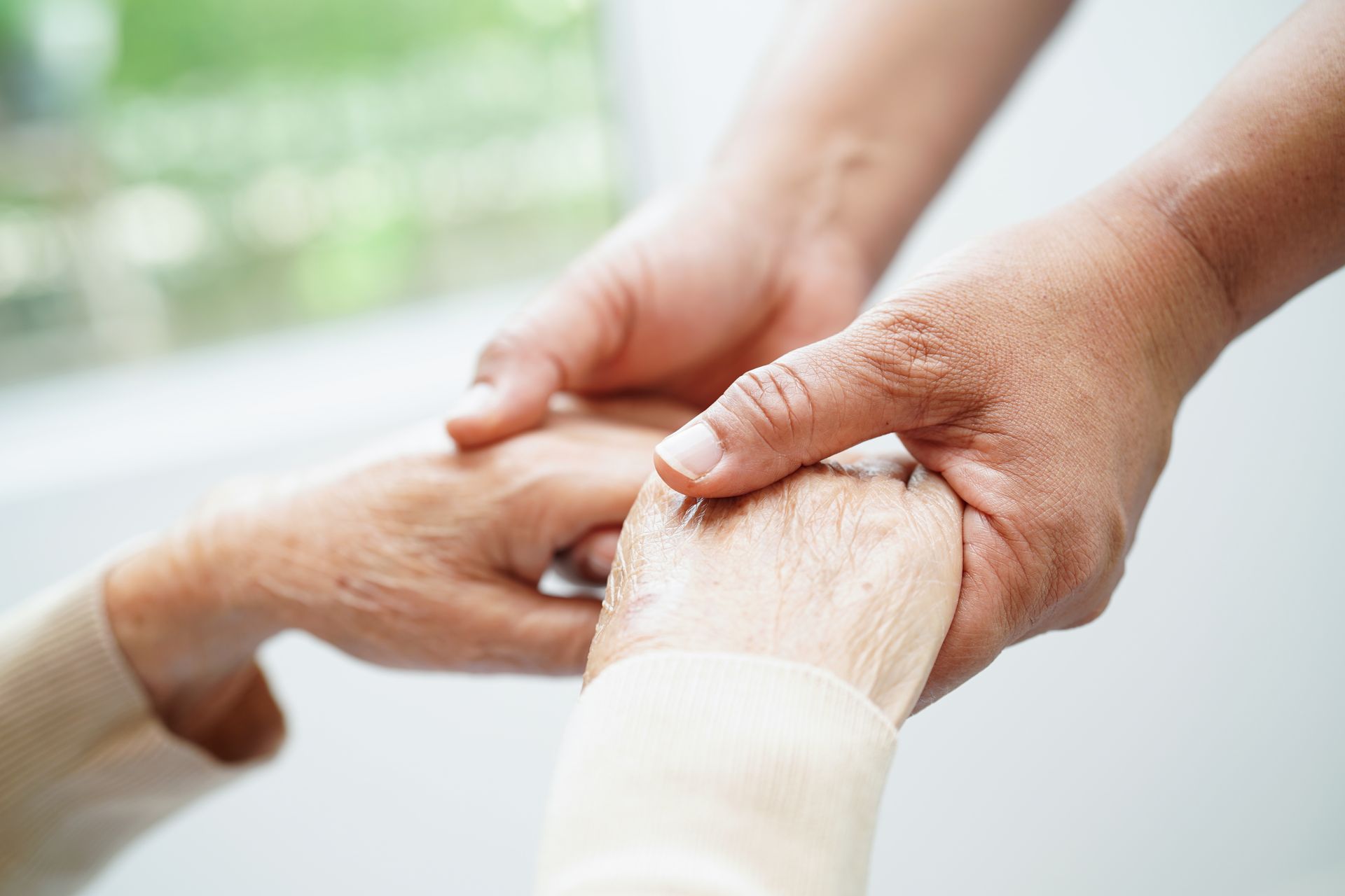 Hands holding a bandaged wrist in a supportive gesture