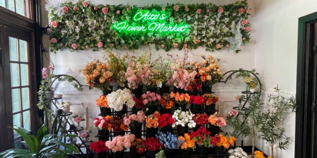 Flower shop display with colorful bouquets and a neon “Open” sign above the counter