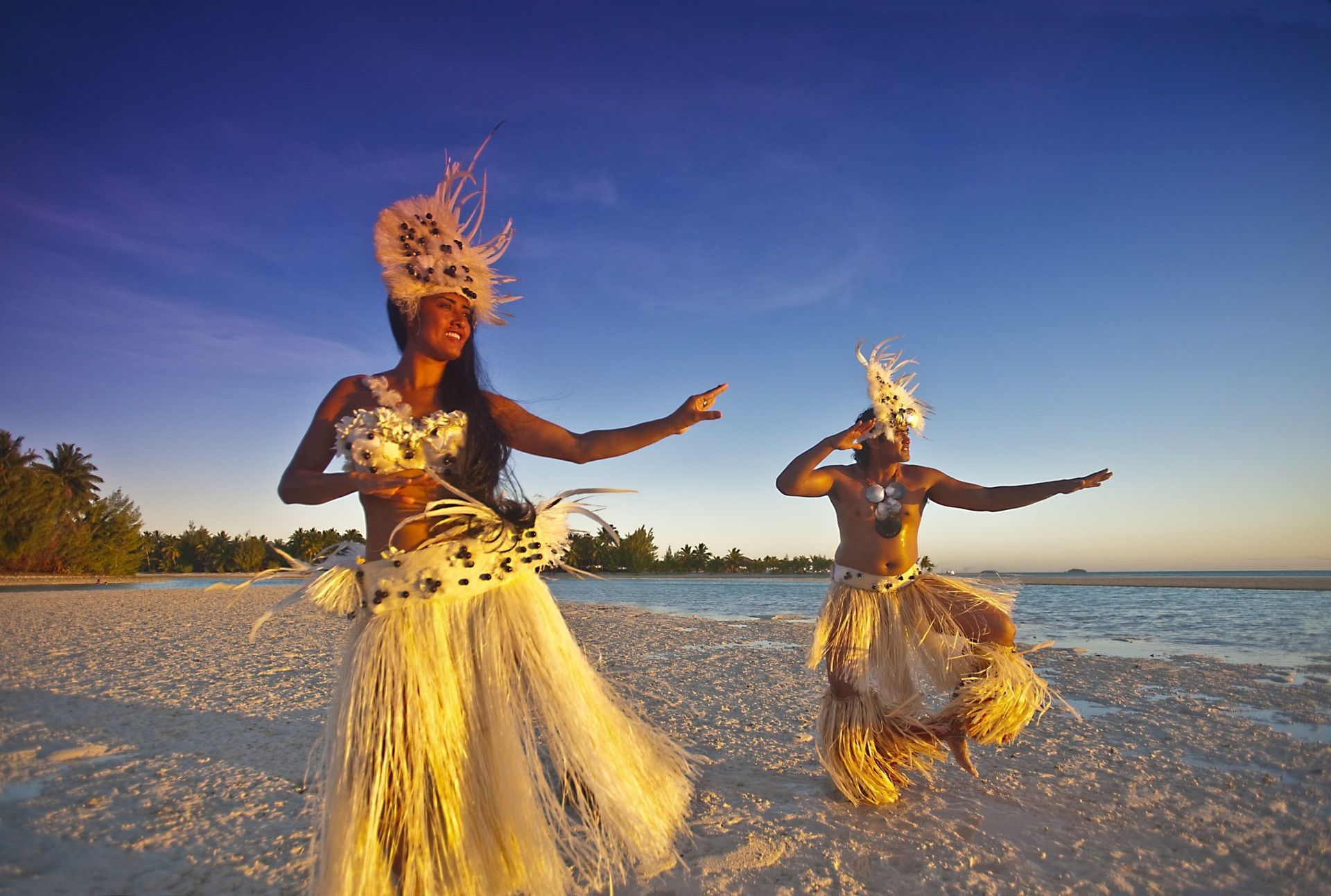 A man and a woman are dancing on a beach.