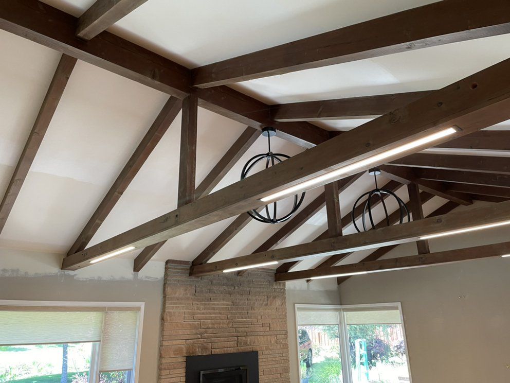 A ceiling with a lot of insulation and wooden beams.