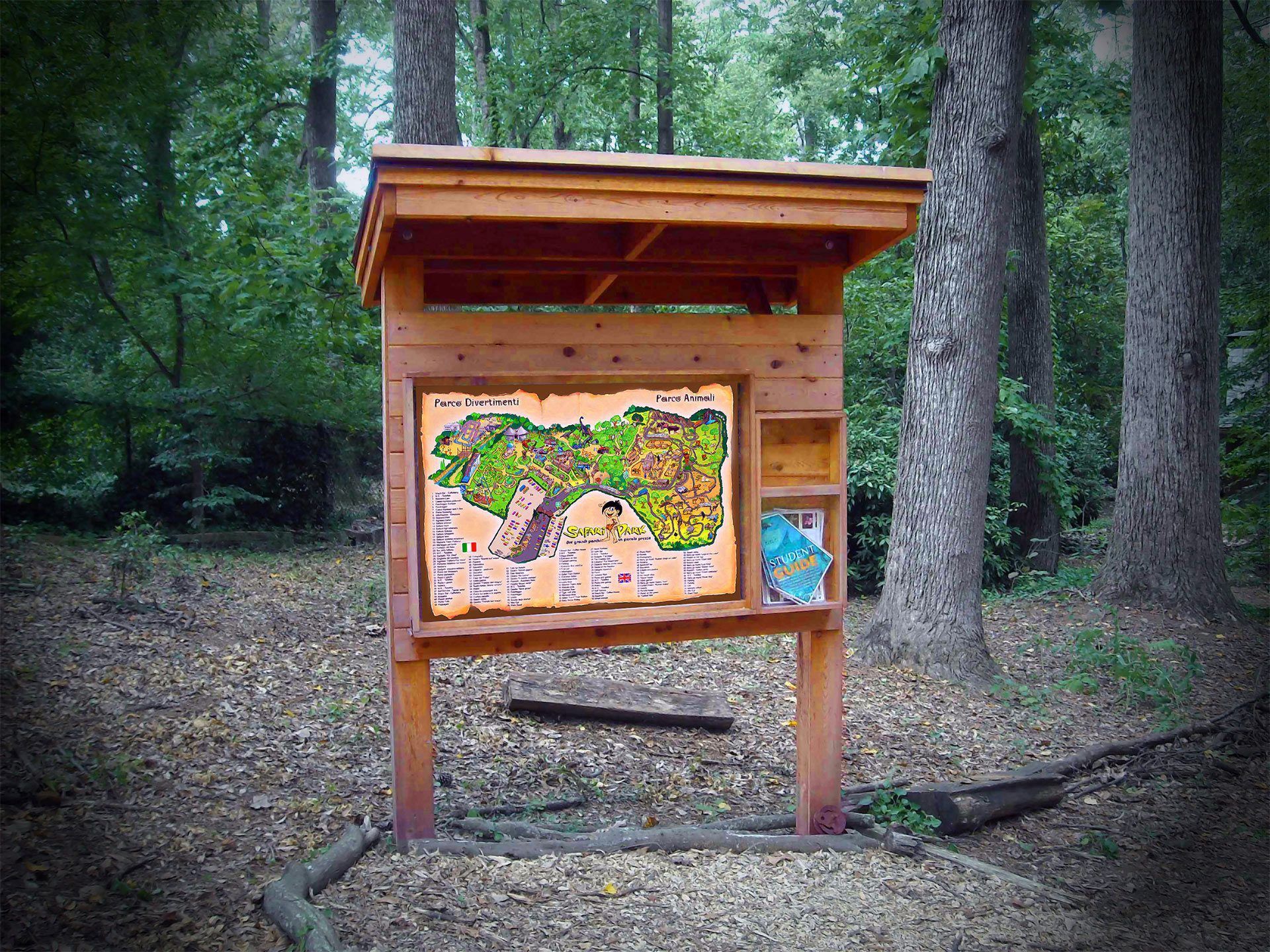 Pannello informativo in legno con mappa colorata in una radura nella foresta.
