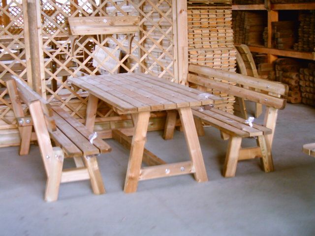 Tavolo da picnic in legno con panche in un ambiente rustico all'aperto o in un'officina.