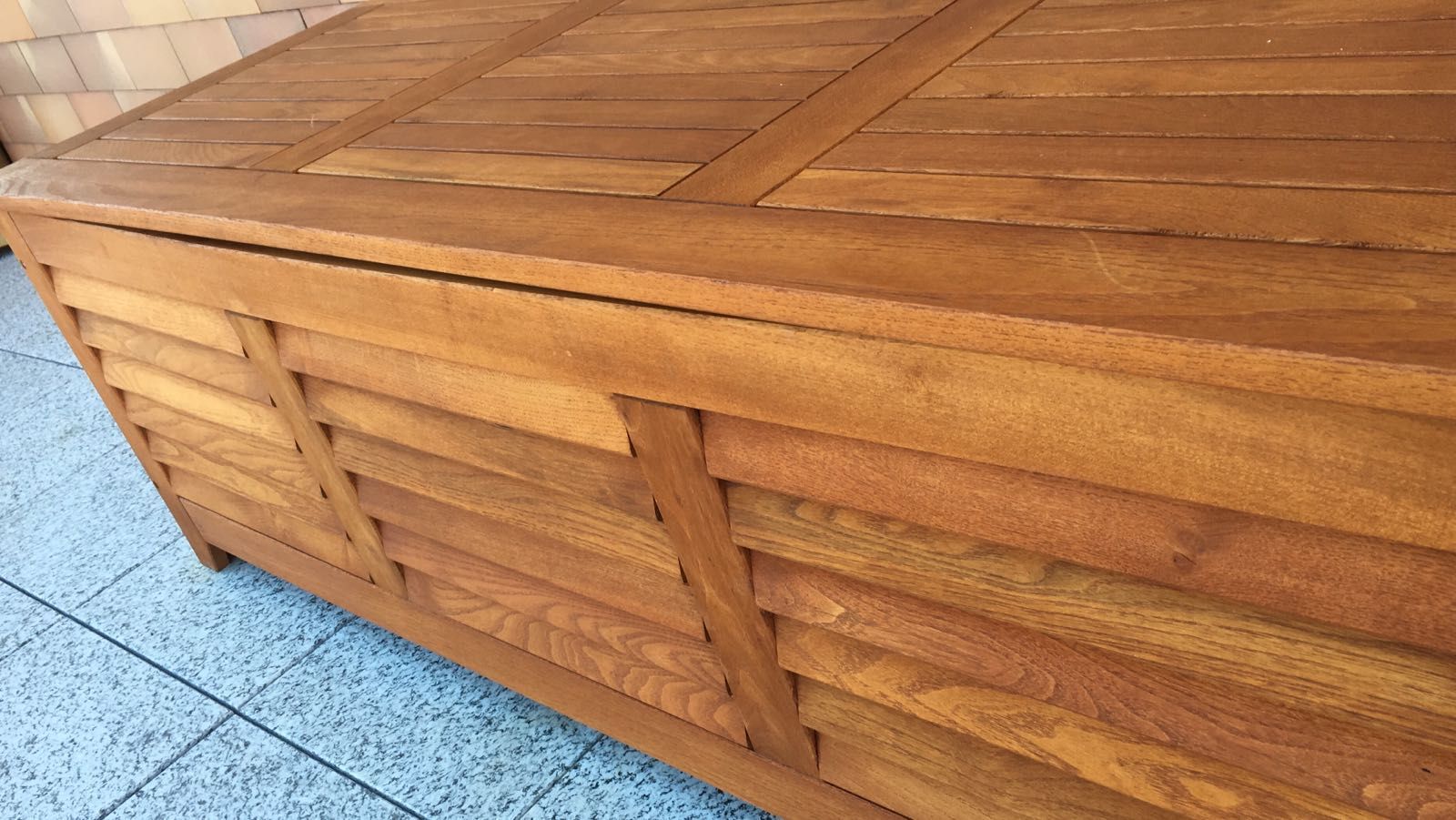 Panchina a doghe di legno o fioriera su pavimento piastrellato di blu