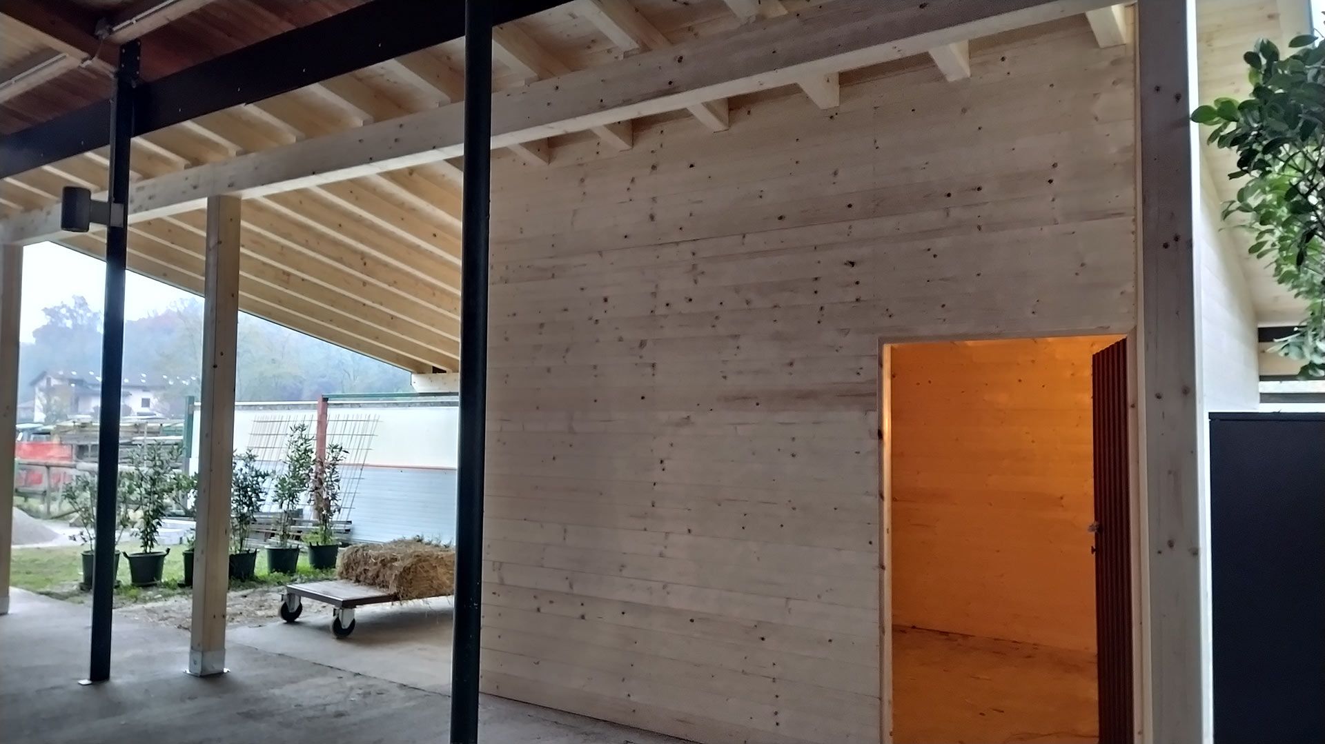 Interni moderni del patio con travi a vista, pareti in cemento e una vista aperta sul lungomare esterno.