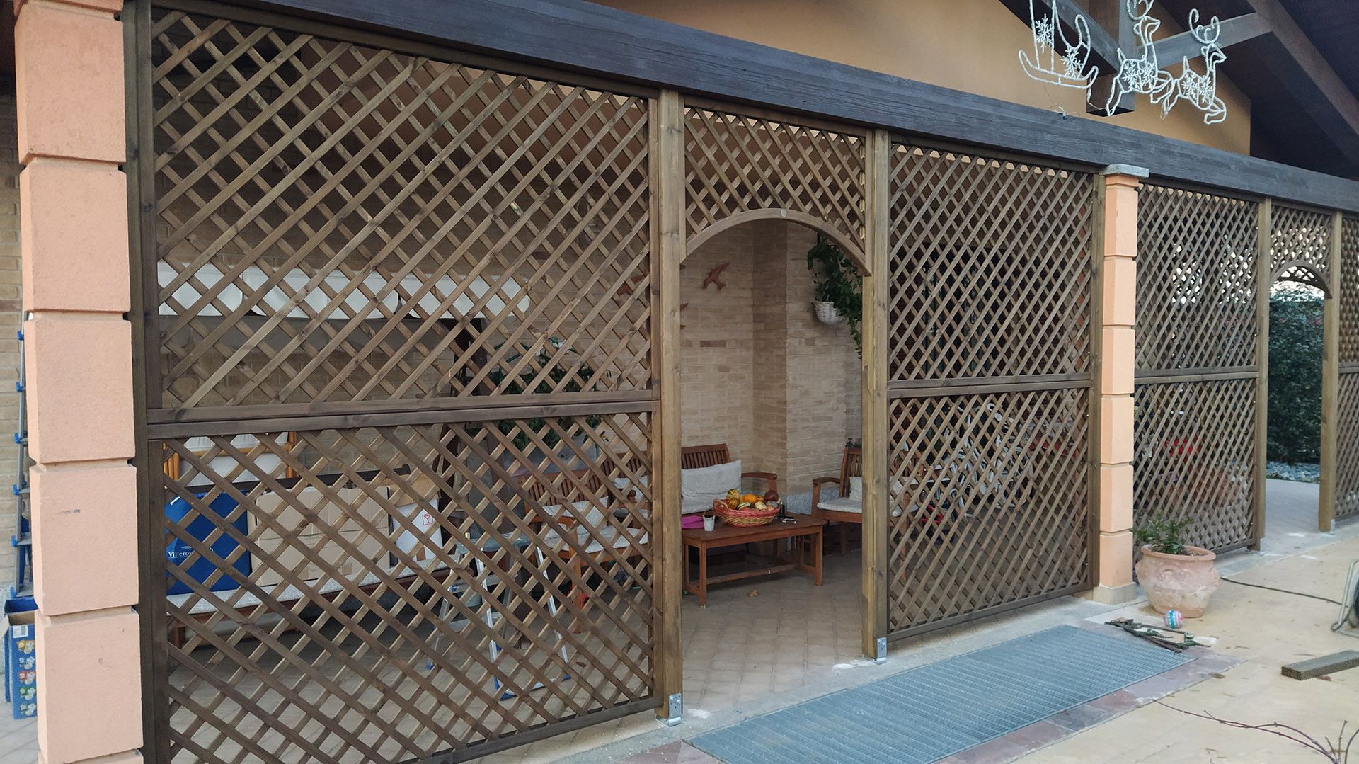 Negozio chiuso con porte a grata metallica e una piccola area espositiva ad arco sul marciapiede.