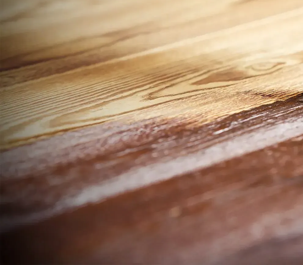 Primo piano di una superficie di legno con venature di colore marrone chiaro e scuro.