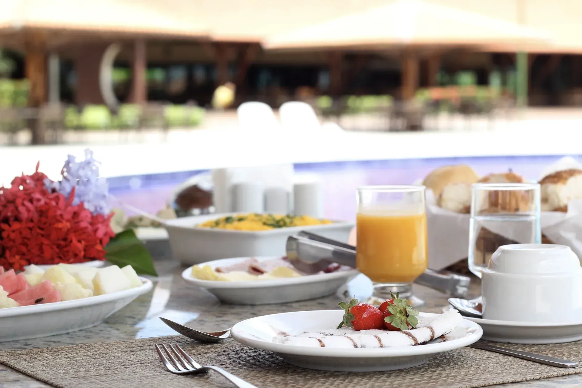Uma mesa coberta com pratos de comida e um copo de suco de laranja.