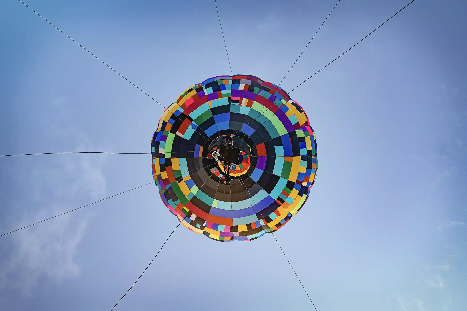 Um balão de ar quente colorido está voando no céu.
