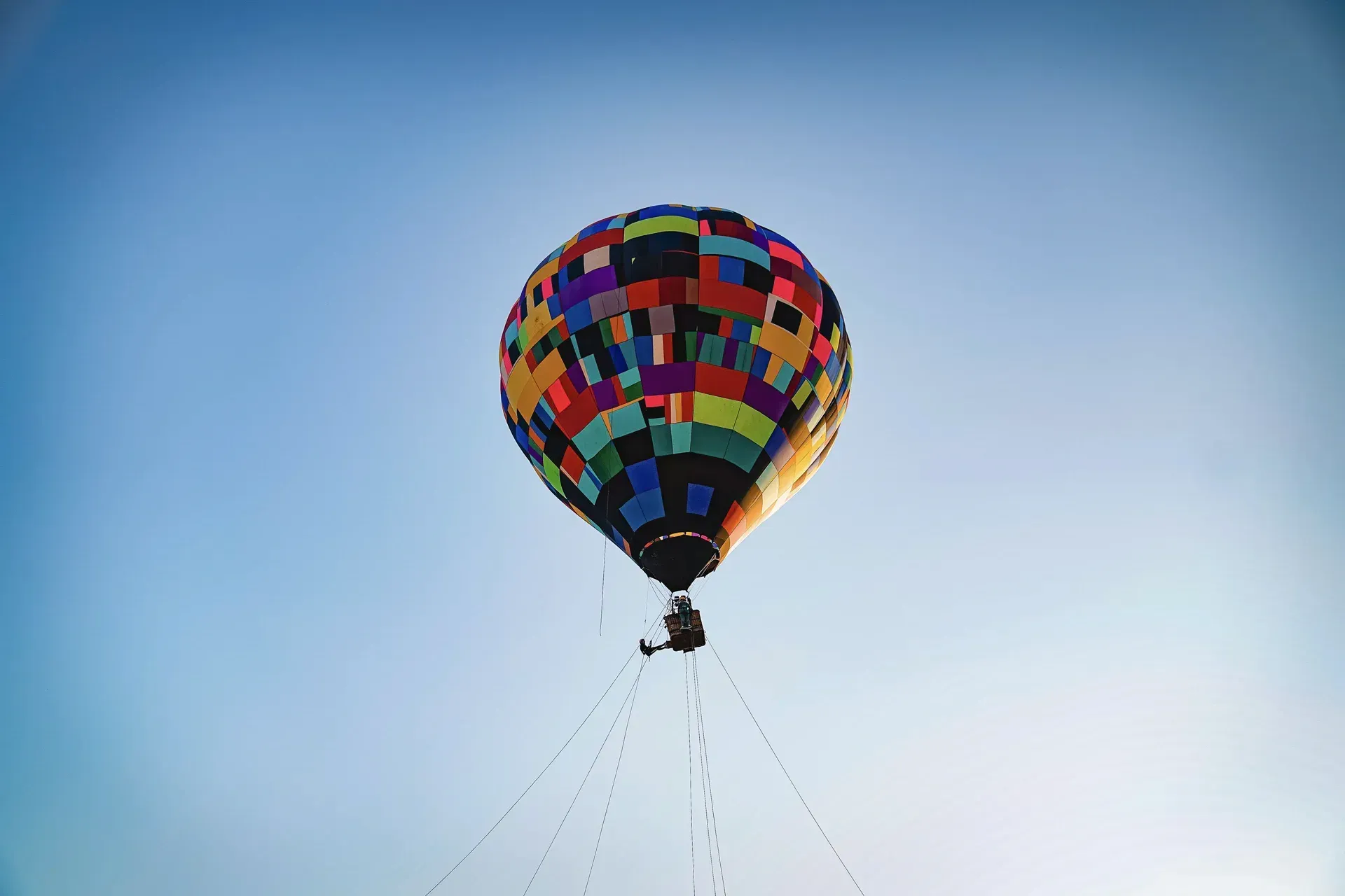 Um balão de ar quente colorido está voando no céu.