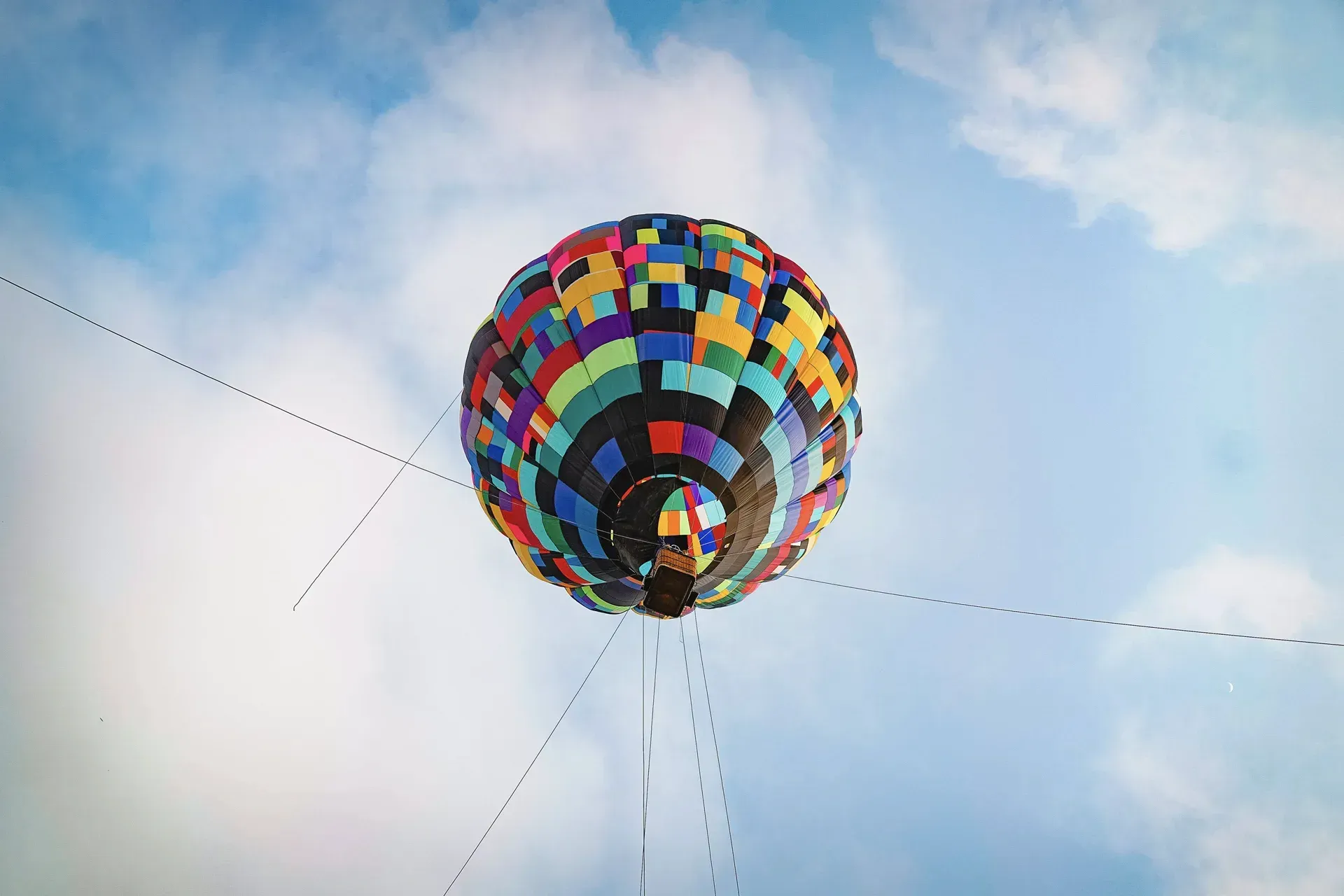 Um balão de ar quente colorido está voando no céu.