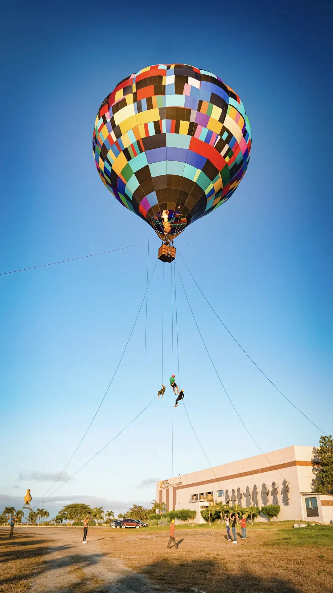Um balão de ar quente colorido está voando no céu sobre um campo.
