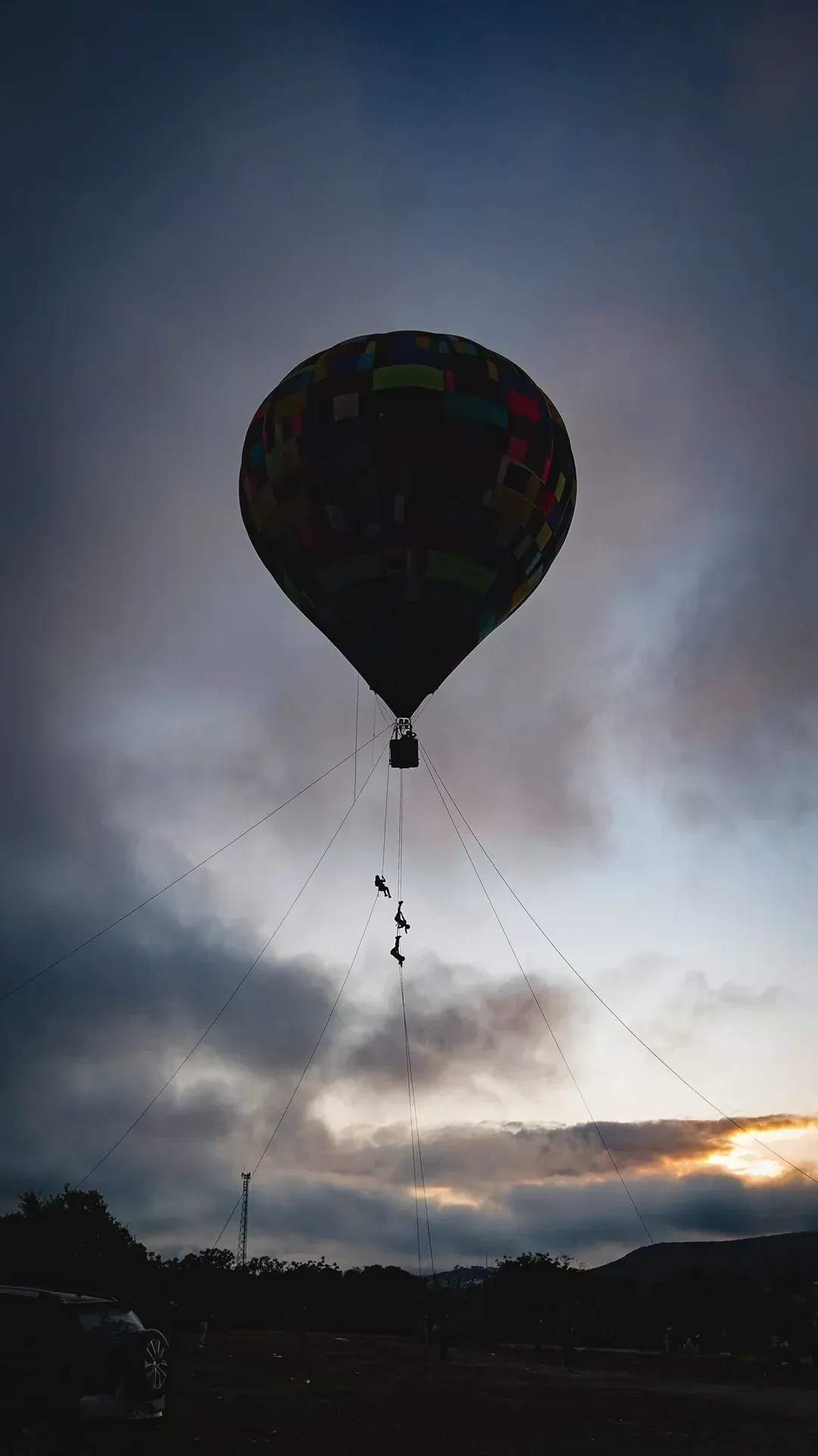 Um balão de ar quente está voando no céu ao pôr do sol.