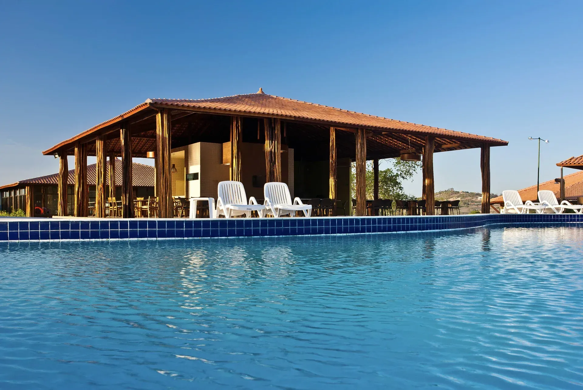 Uma piscina com cadeiras e um prédio ao fundo