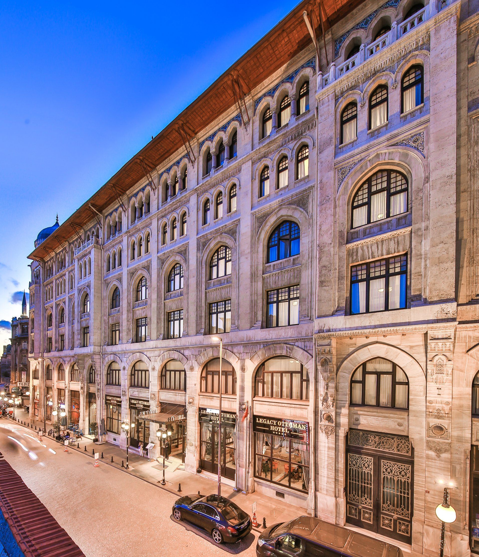 A large building with a lot of windows and cars parked in front of it