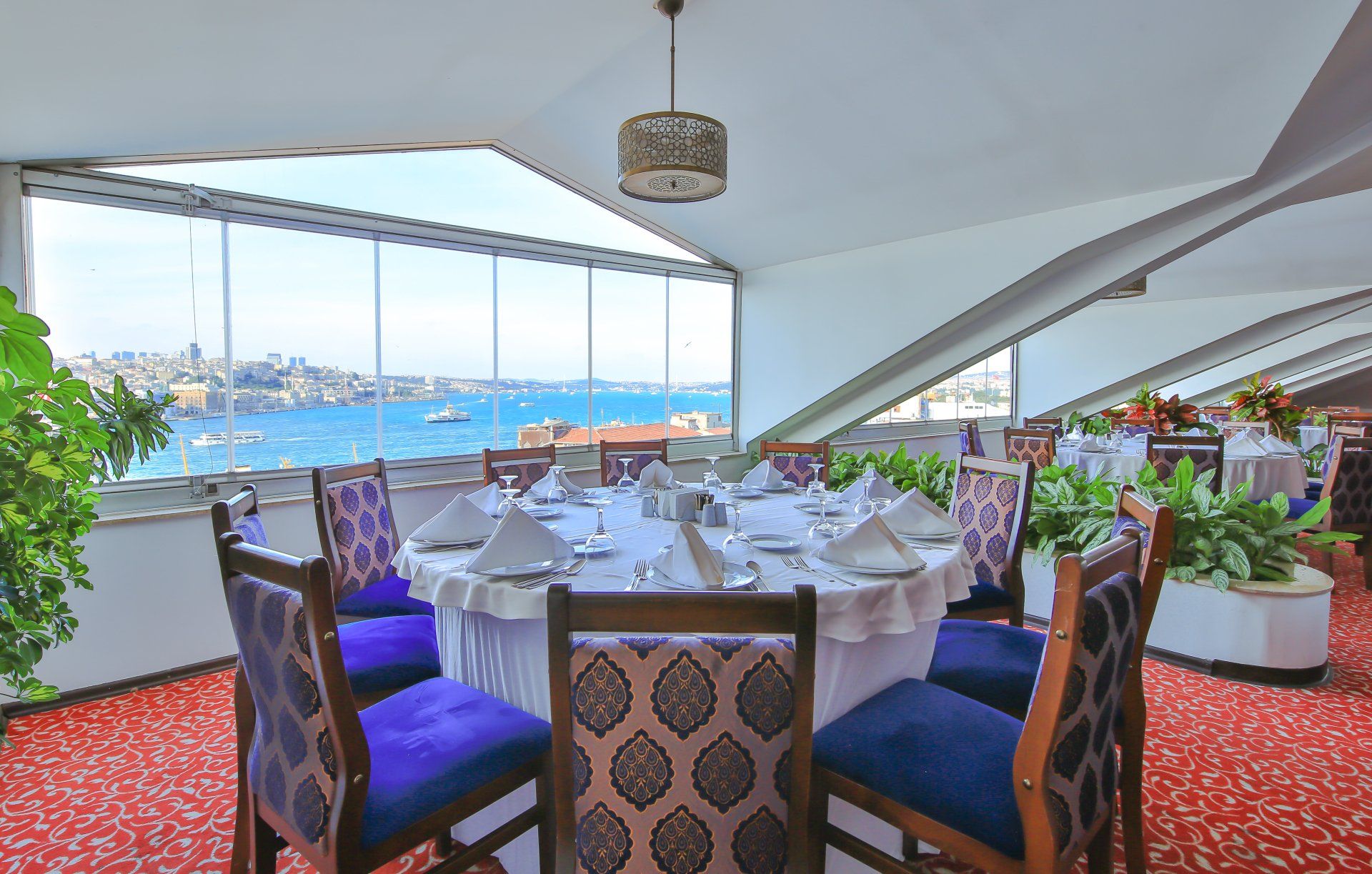 A restaurant with tables and chairs and a view of the ocean