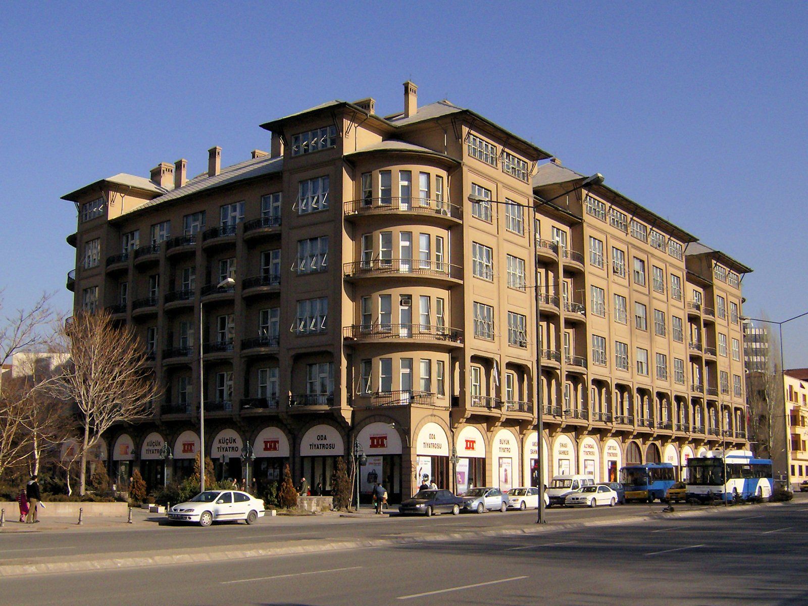 A large building with a lot of windows and cars parked in front of it