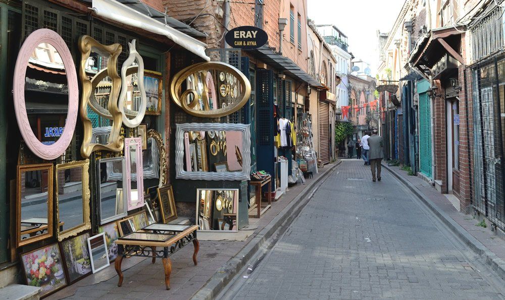 A narrow street with a lot of mirrors on the side of it