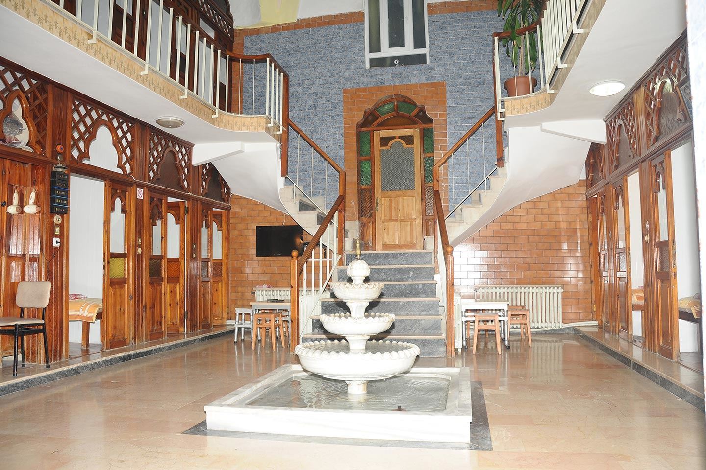 A large room with stairs and a fountain in the middle