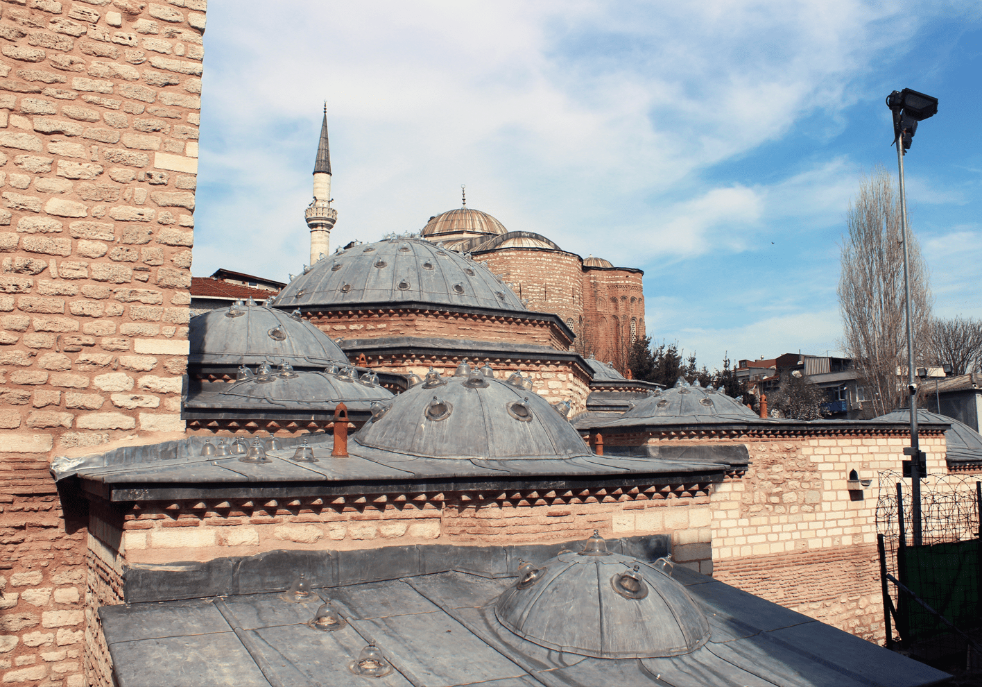 A rooftop view of a brick building with a mosque in the background
