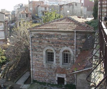 A brick building with arched windows and a tiled roof