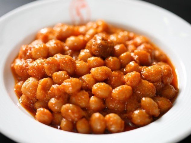 A white bowl filled with chickpeas in tomato sauce
