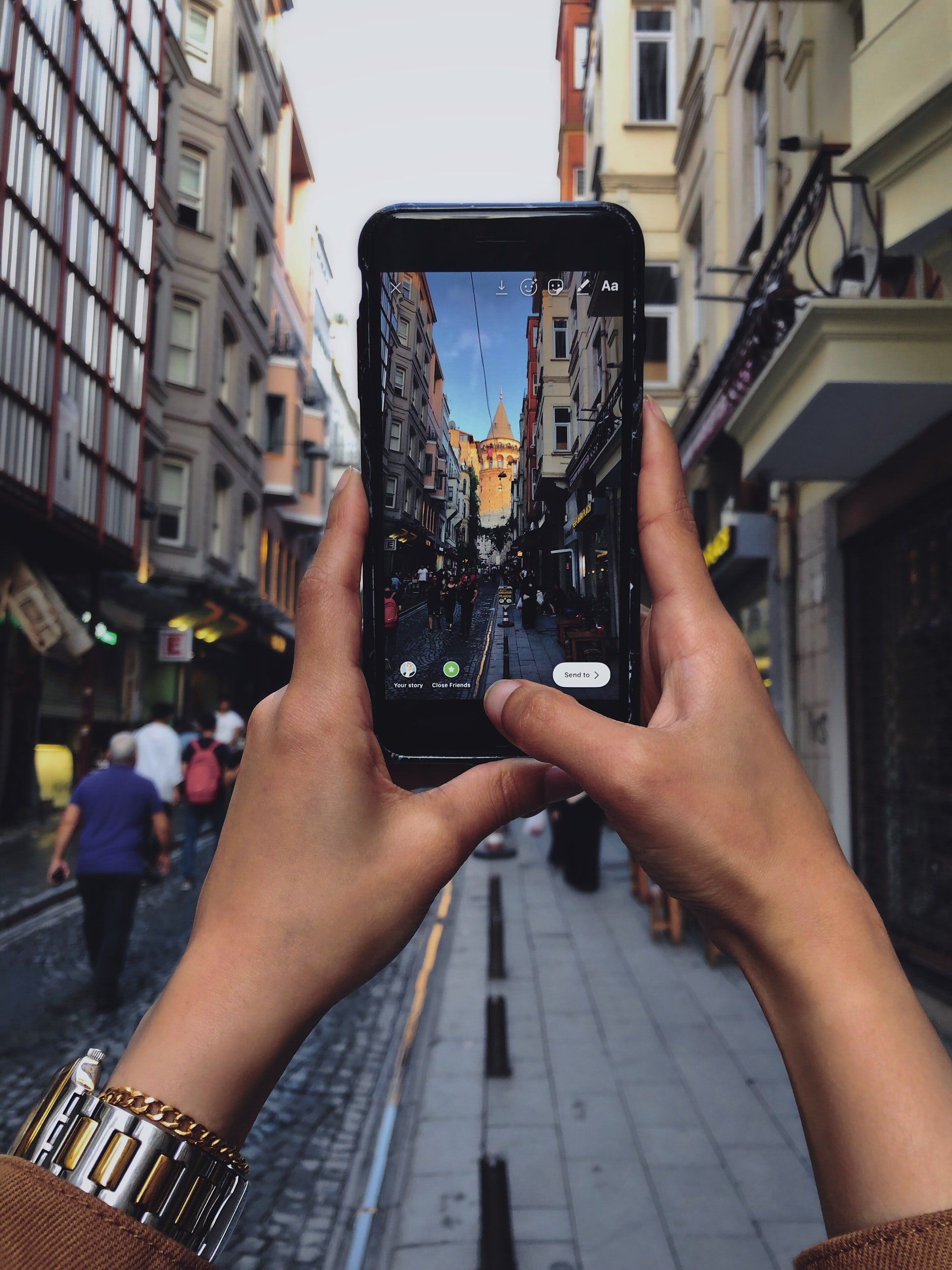 A person is taking a picture of a city street with a cell phone