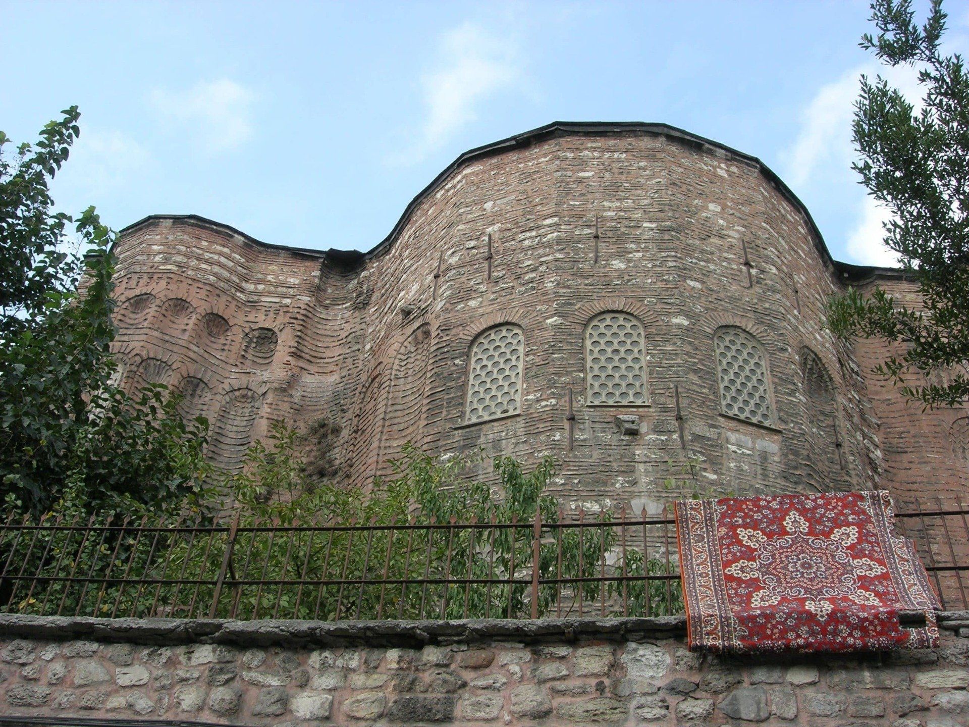 A brick building with a red rug on the side of it