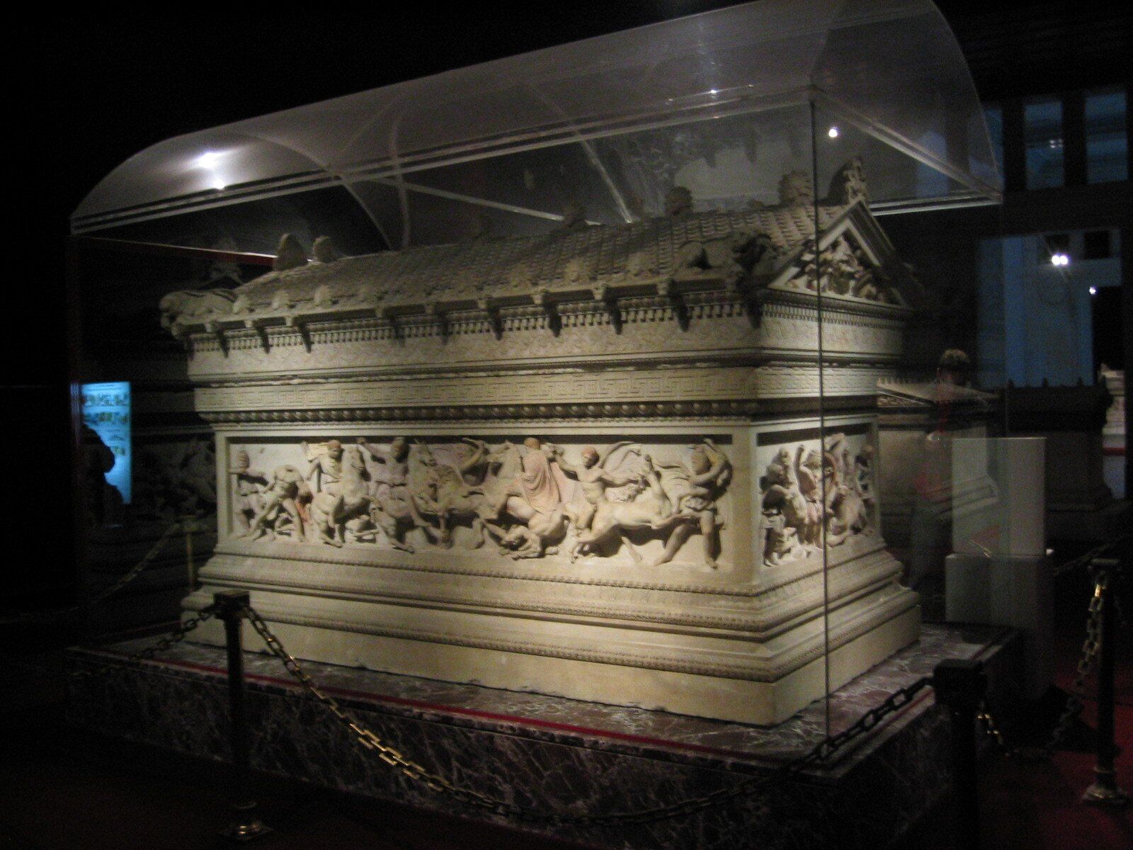 A large statue is displayed in a glass case