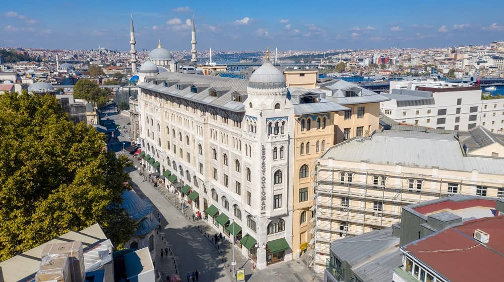 An aerial view of a city with a large building in the middle of it.
