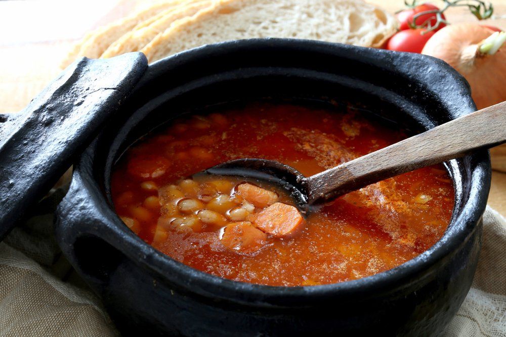 A bowl of soup with a spoon in it.