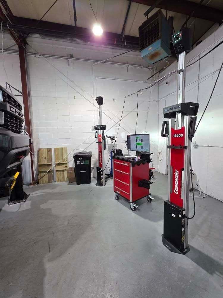Empty auto repair bay with a red tool cabinet, tire machine, and ceiling lights against white walls | Best Choice Service