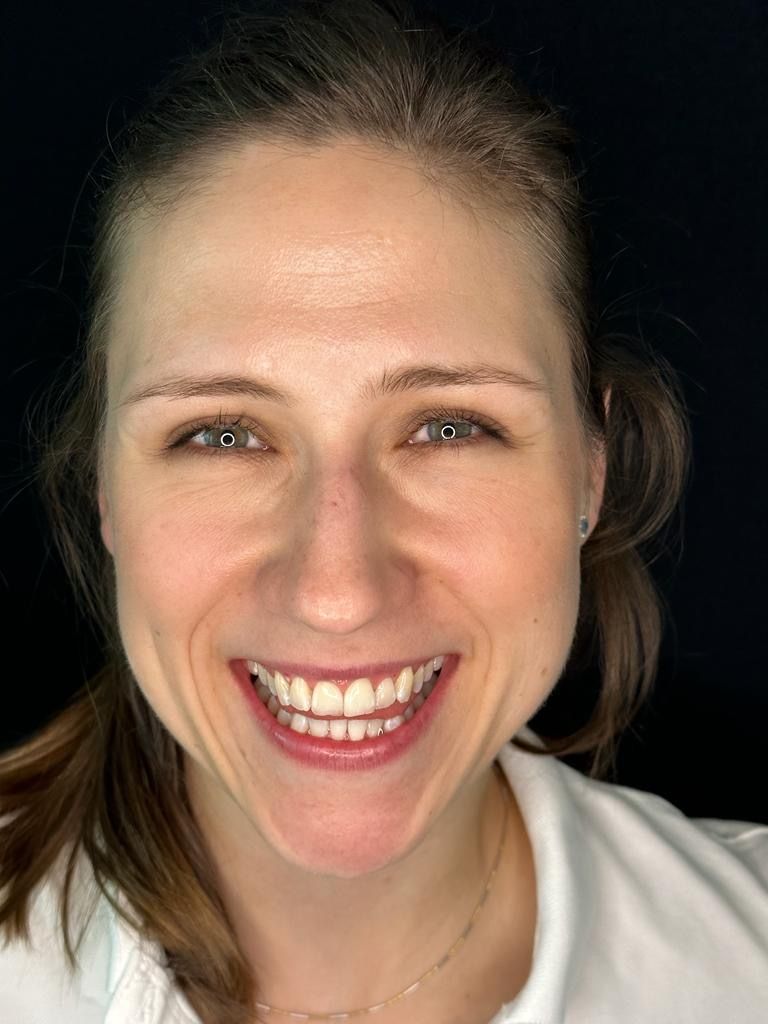Donna sorridente con occhi azzurri su sfondo scuro