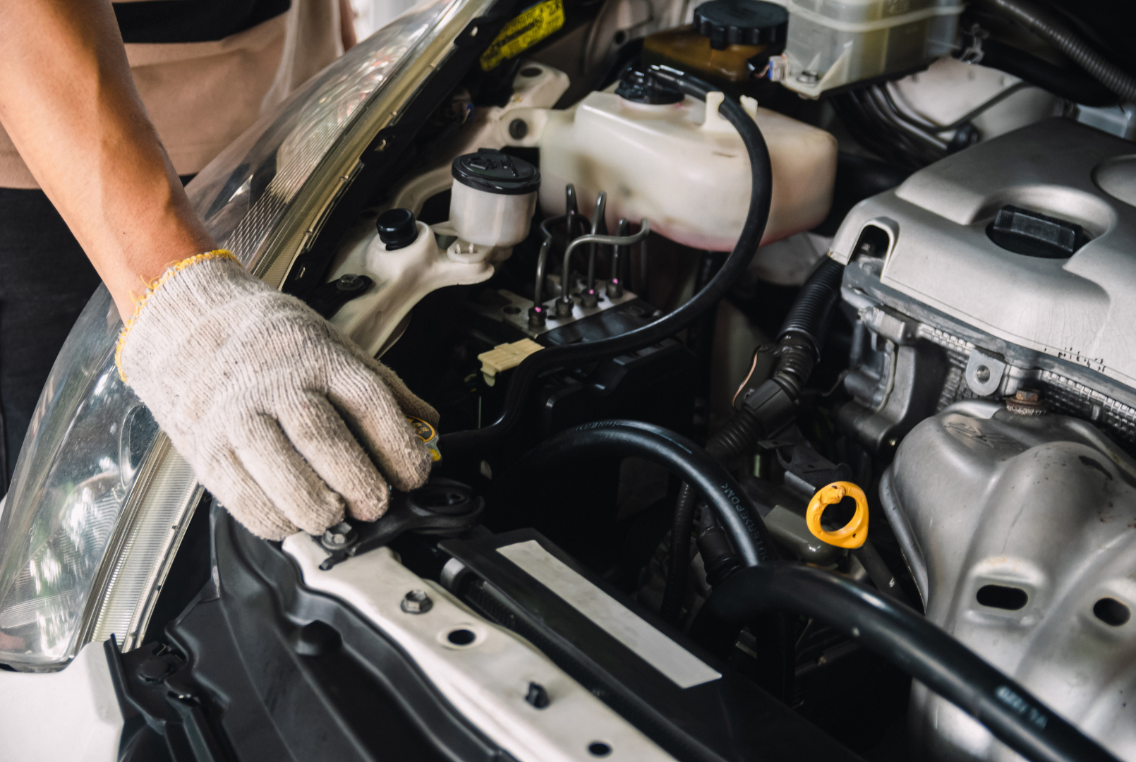 A man is working on the engine of a car.