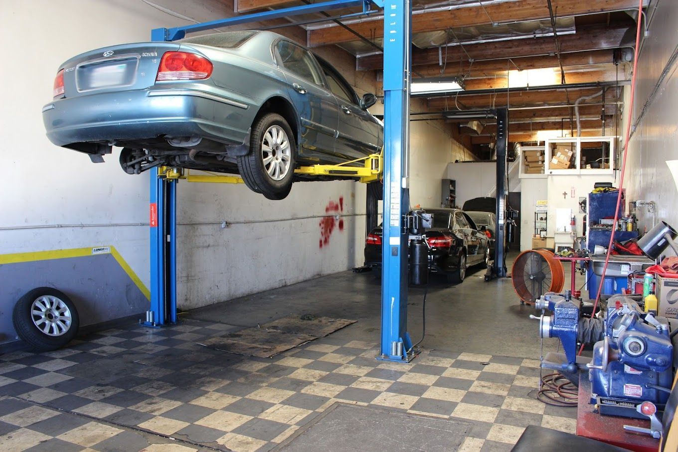 A car is sitting on a lift in a garage.