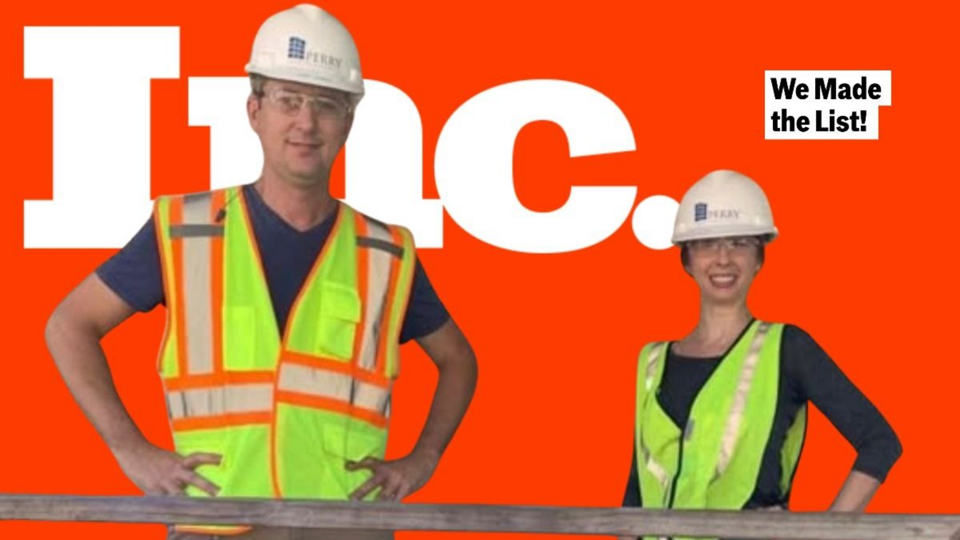 Two people in hard hats and safety vests stand in front of an 