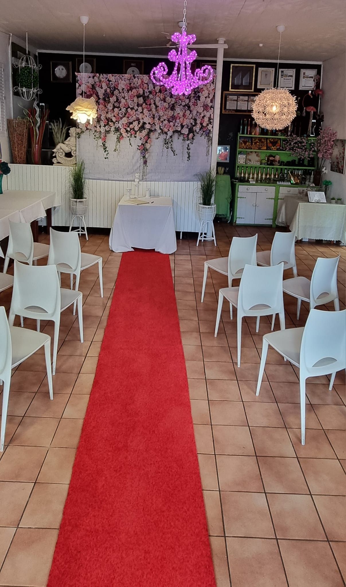 A room with a red carpet and white chairs  — Wayne & Adele's Garden of Eating BYO Restaurant In South Townsville, QLD