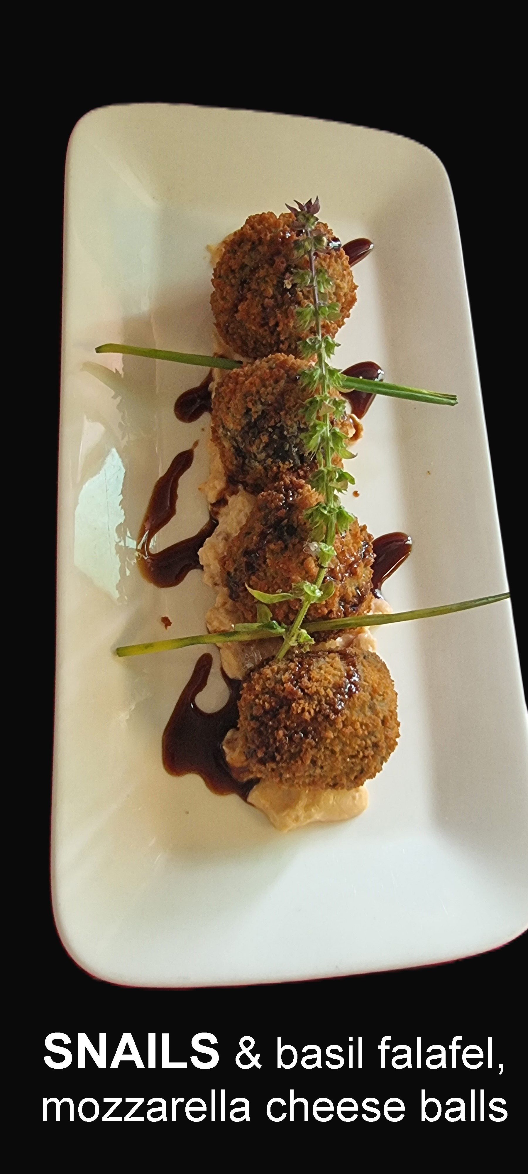 A white plate Topped with Snails and basil falafel — Wayne & Adele's Garden of Eating BYO Restaurant In South Townsville, QLD