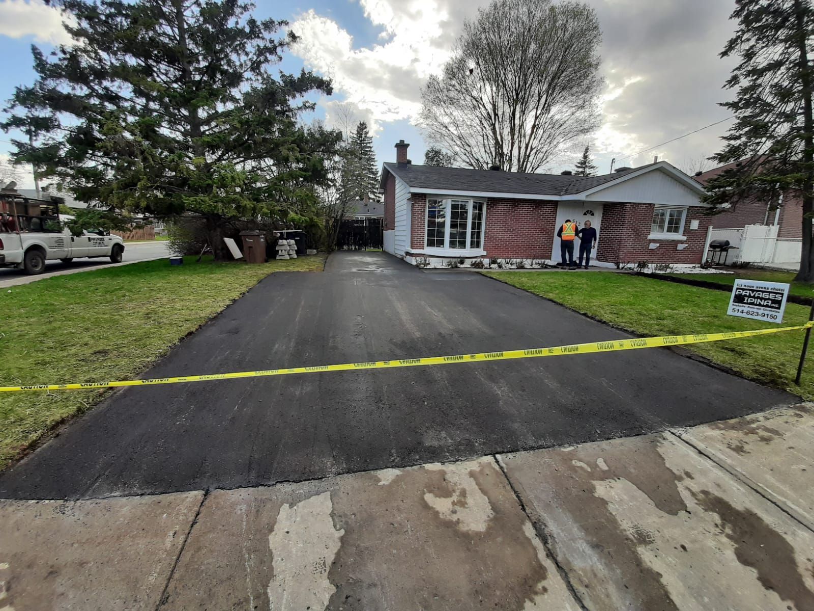 Une allée est en train d'être pavée devant une maison.