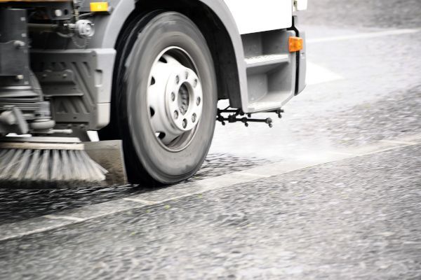 A truck is sweeping the road with a brush