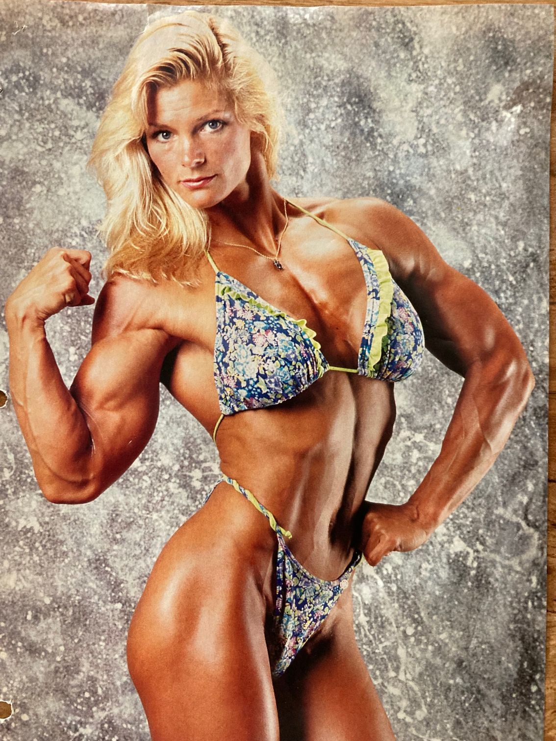 A woman in a bikini is flexing her muscles