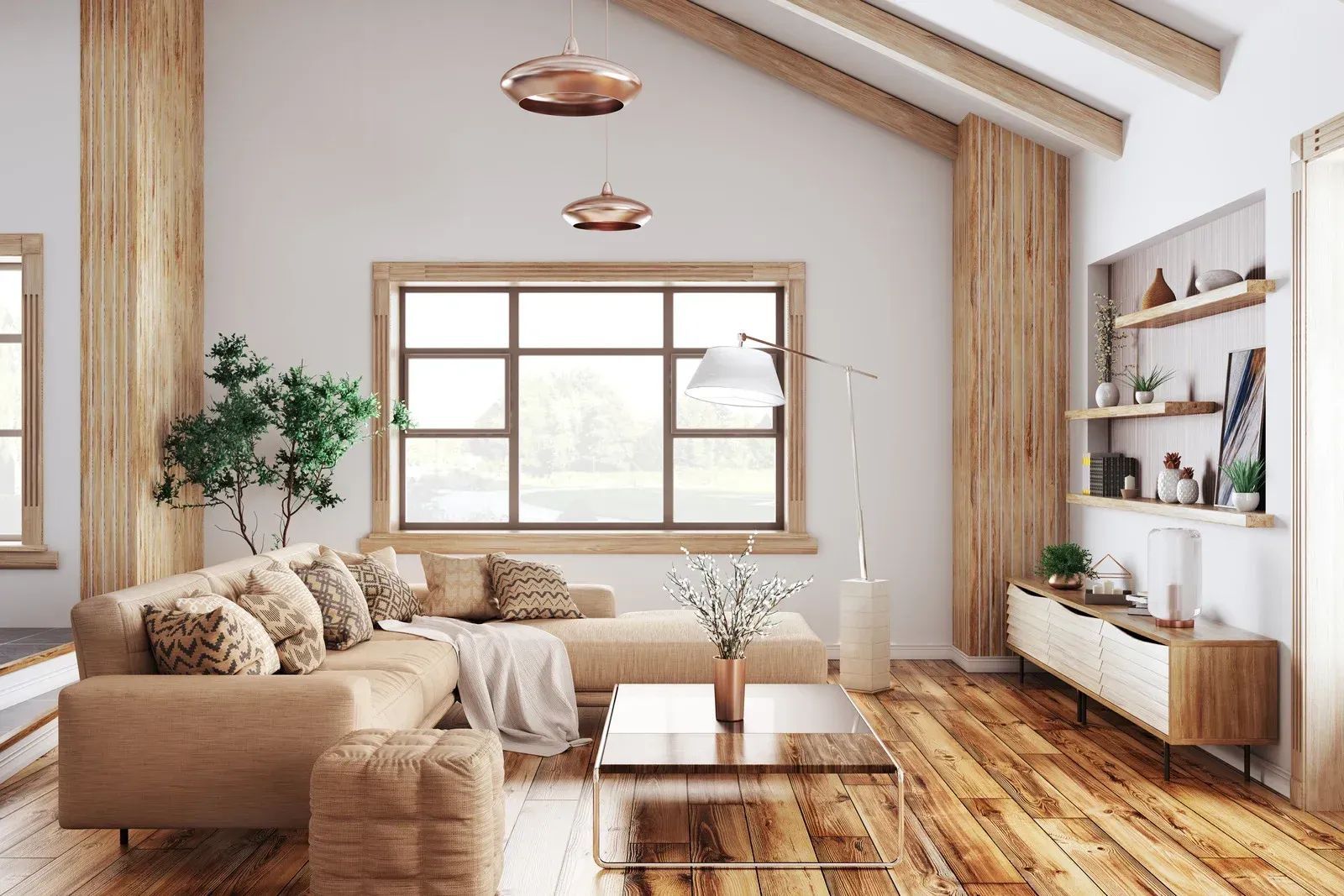 Cozy living room with tan sectional sofa, wooden floors, and large window overlooking greenery.