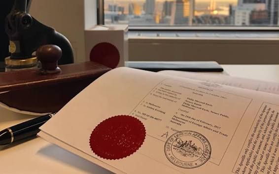 State apostille and federal authentication documents with passport, seals, and legal paperwork on of