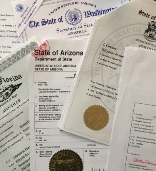 Power of attorney document with apostille seal, notary stamp, passport, and legal paperwork on offic