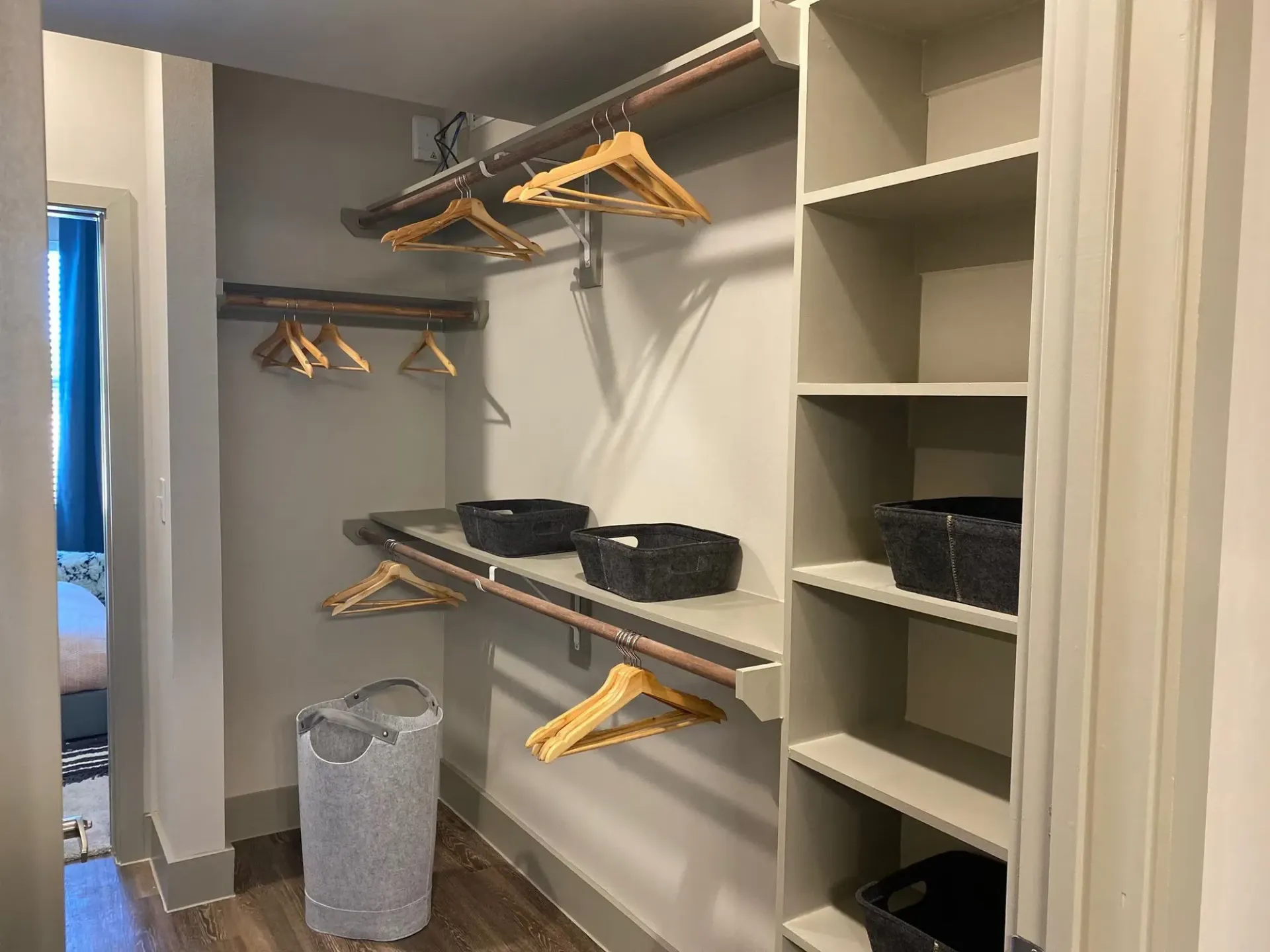 Walk-in closet with shelves, hanging rods, and fabric storage baskets.